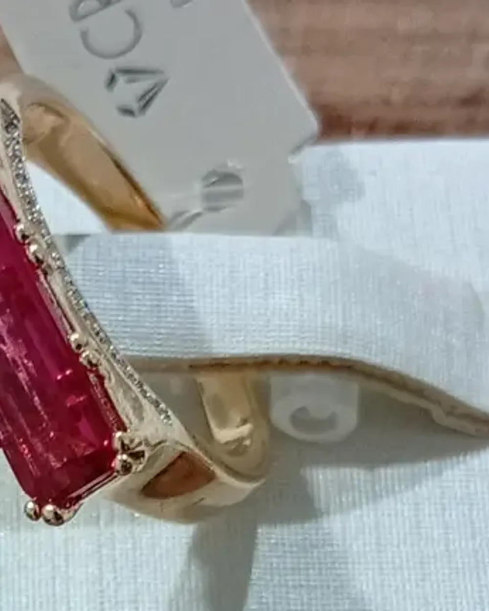 Anel dourado com pedra vermelha retangular tipo rubi
