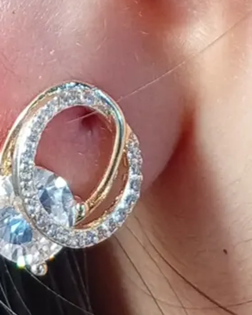 Ear cuff dourado com zircônias usado na orelha