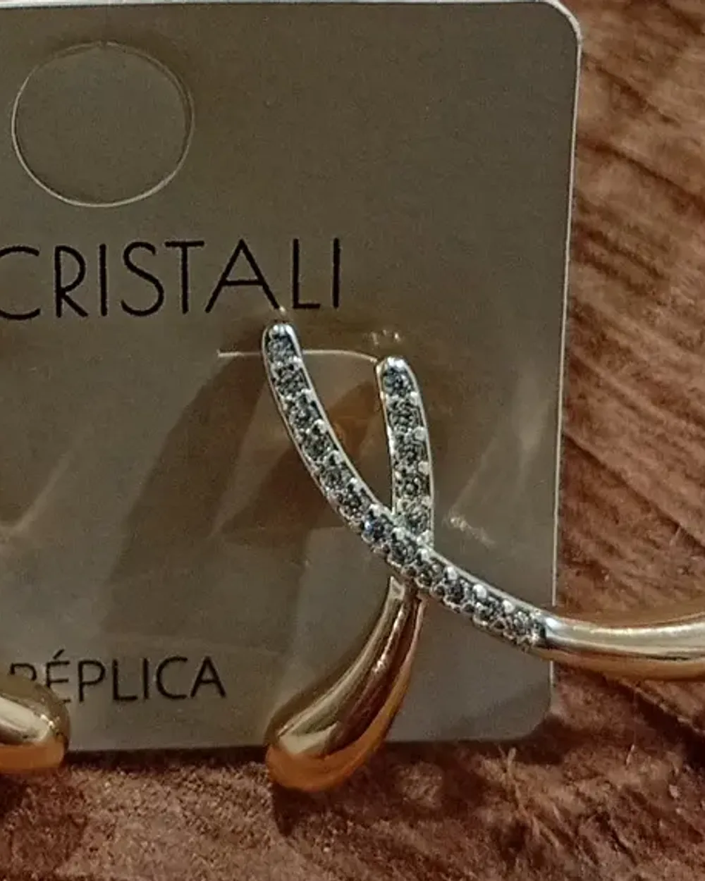 Brinco dourado modelo ear hook, curvado, cravejado de zircônias