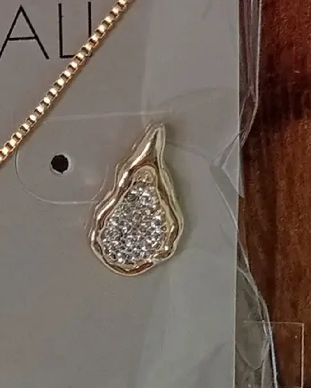 Brinco dourado de gota irregular cravejada de zircônias