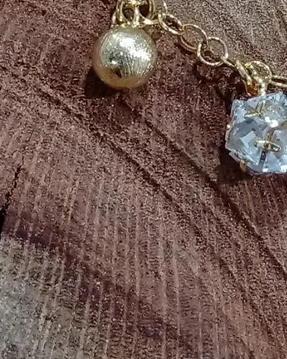 Pulseira dourada com berloques de bolas foscas e cristal
